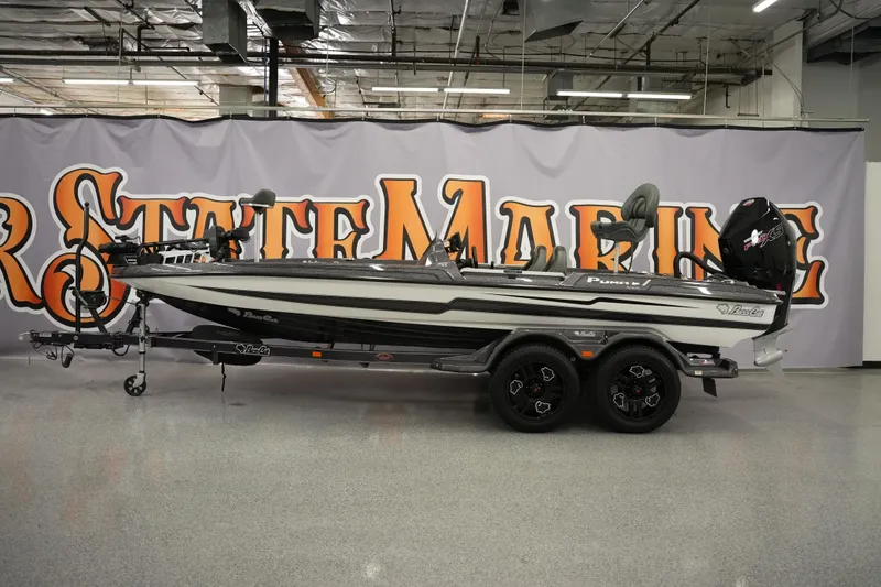 The Image of 2025 Bass Cat Puma STS boat displayed indoors with a branded backdrop. - 1