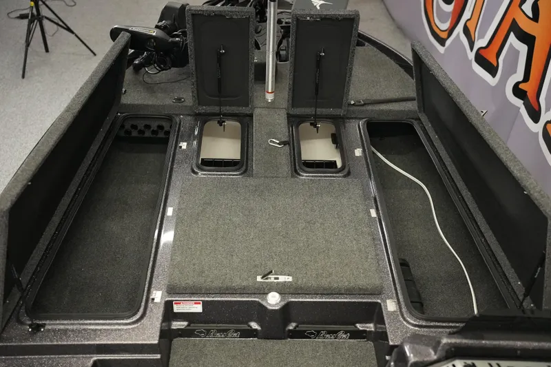 Slide: The Image of 2025 Bass Cat Puma STS boat storage compartments with carpeted interior and secure latches. - 16