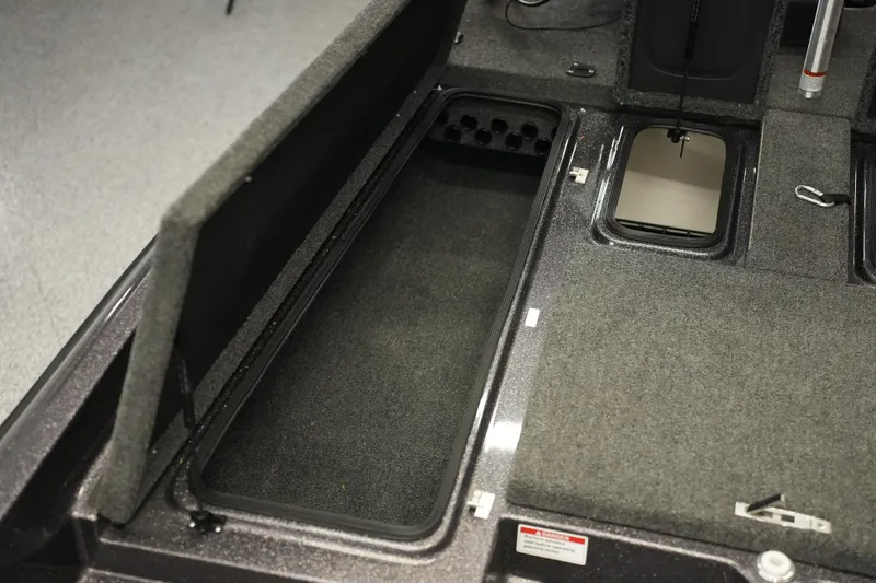 Slide: The Image of 2025 Bass Cat Puma STS boat interior with open storage compartments and carpeted deck. - 17