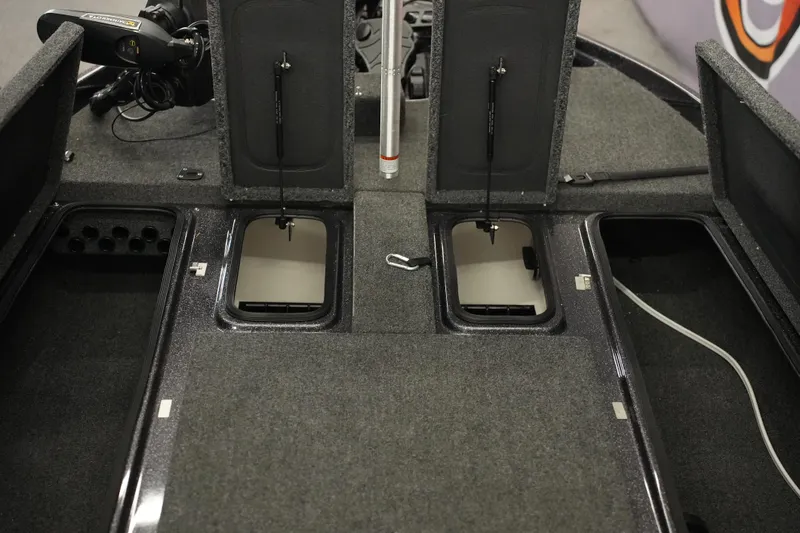 Slide: The Image of Interior storage compartment of 2025 Bass Cat Puma STS boat, featuring carpeted finish and wiring. - 18
