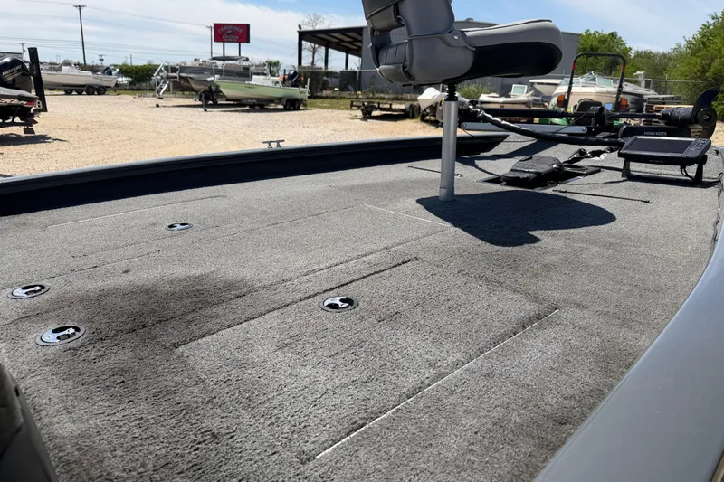 Slide: The Image of 2018 Tracker Pro Team 190 TX boat deck with seating and equipment in a marina. - 8