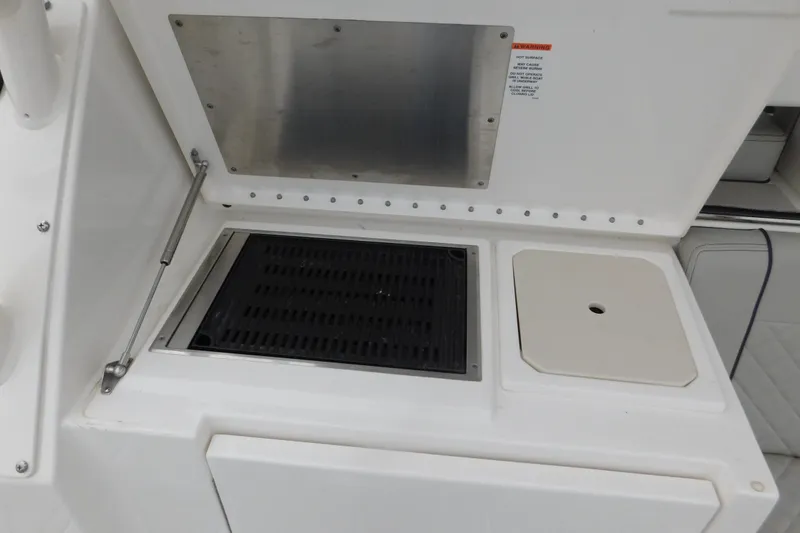 Slide: The Image of 2023 Pursuit OS 325 Offshore boat kitchen area with grill and sink. - 14