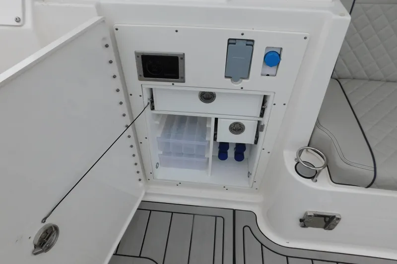 Slide: The Image of 2023 Pursuit OS 325 Offshore boat storage compartment with drawers and cup holder. - 16