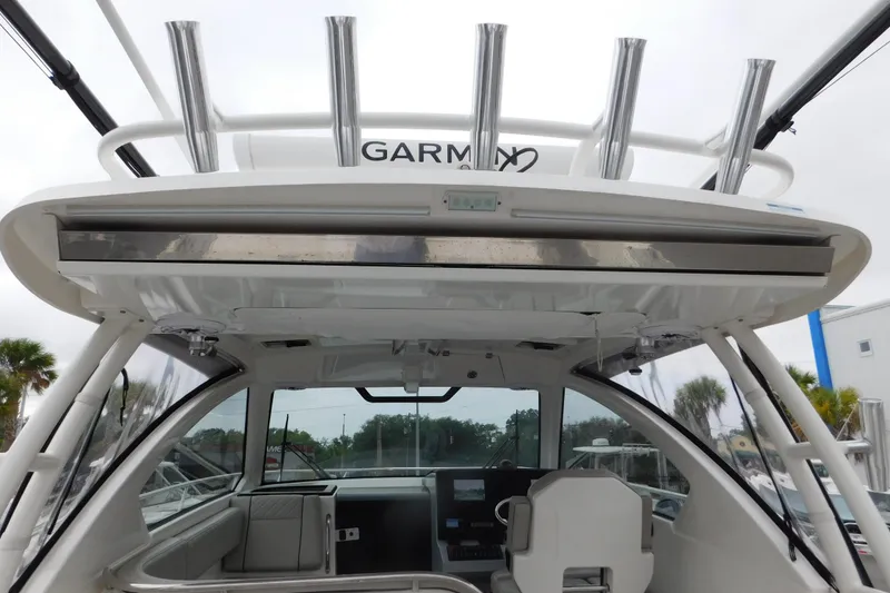 Slide: The Image of 2023 Pursuit OS 325 Offshore boat interior with helm and rod holders. - 19