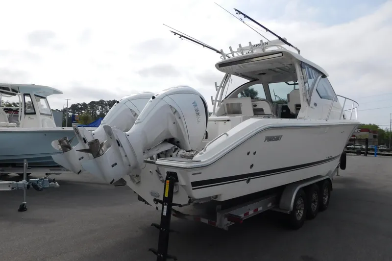 Slide: The Image of 2023 Pursuit OS 325 Offshore boat on trailer, featuring dual outboard engines. - 2