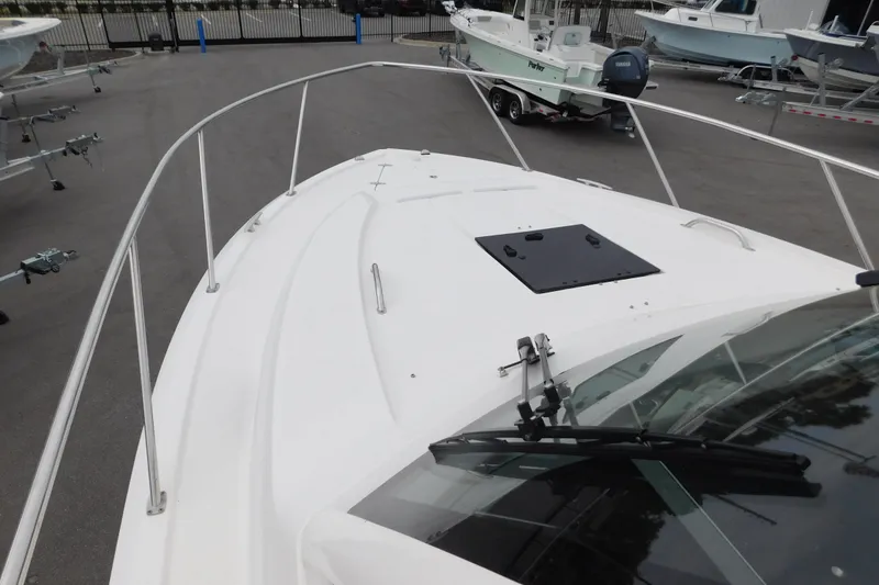 Slide: The Image of 2023 Pursuit OS 325 Offshore boat deck with railing and hatch, parked on a trailer. - 21