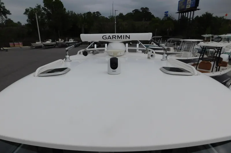 Slide: The Image of 2023 Pursuit OS 325 Offshore boat with Garmin radar, docked among other vessels. - 22