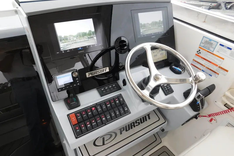 Slide: The Image of Helm of 2023 Pursuit OS 325 Offshore boat with advanced navigation controls and displays. - 29