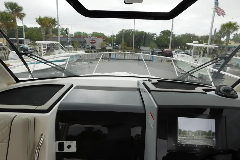 Slide: The Image of 2023 Pursuit OS 325 Offshore boat dashboard with navigation screen and windshield view. - 30