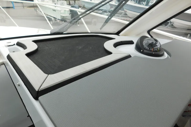 Slide: The Image of 2023 Pursuit OS 325 Offshore dashboard with compass and storage area. - 32