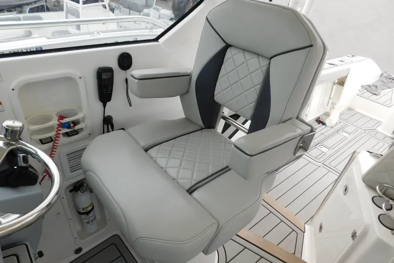 Slide: The Image of Captain's chair on 2023 Pursuit OS 325 Offshore boat, featuring quilted upholstery and modern controls. - 34