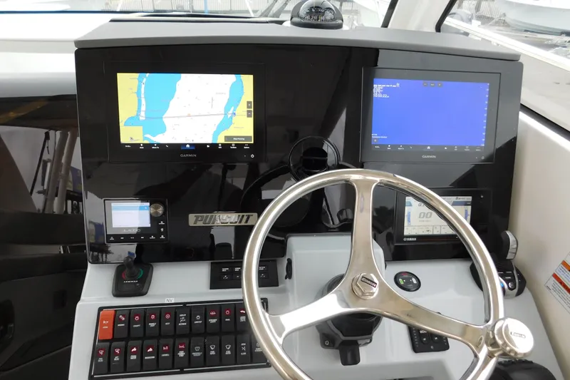 Slide: The Image of 2023 Pursuit OS 325 Offshore helm with Garmin displays and steering wheel. - 36