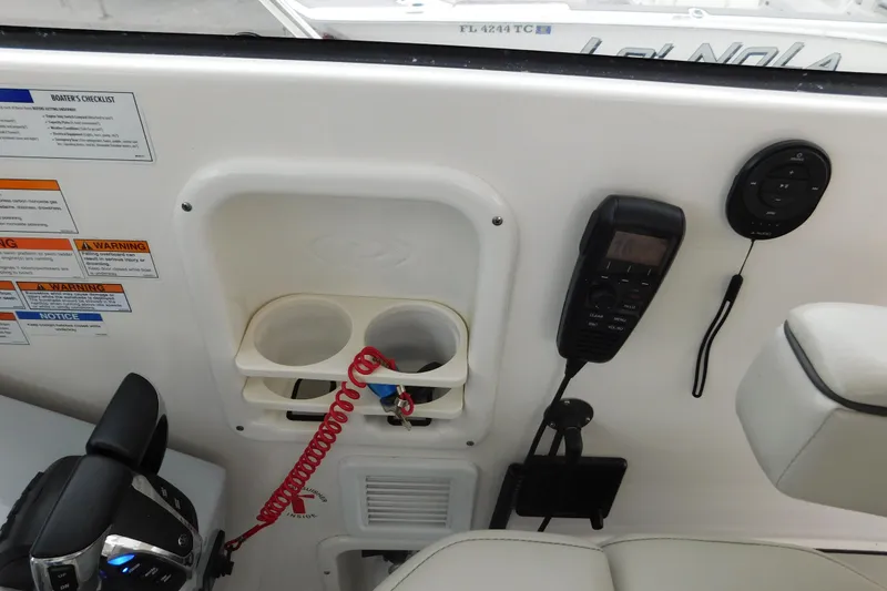 Slide: The Image of 2023 Pursuit OS 325 Offshore boat dashboard with controls, cup holders, and communication devices. - 37