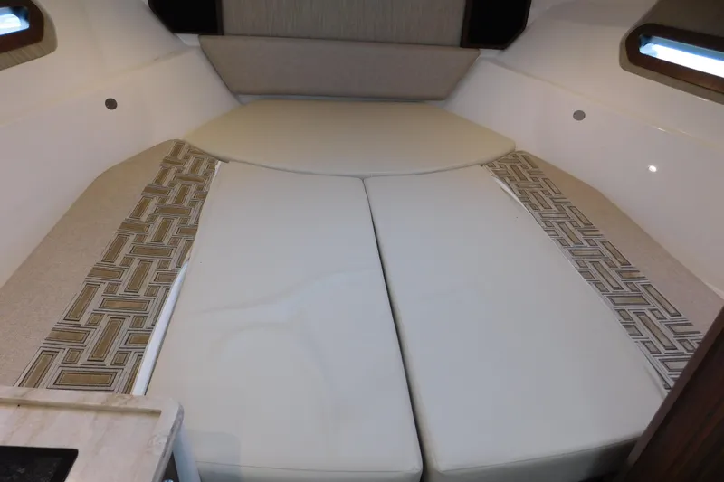 Slide: The Image of 2023 Pursuit OS 325 Offshore cabin interior with cushioned seating and patterned accents. - 39