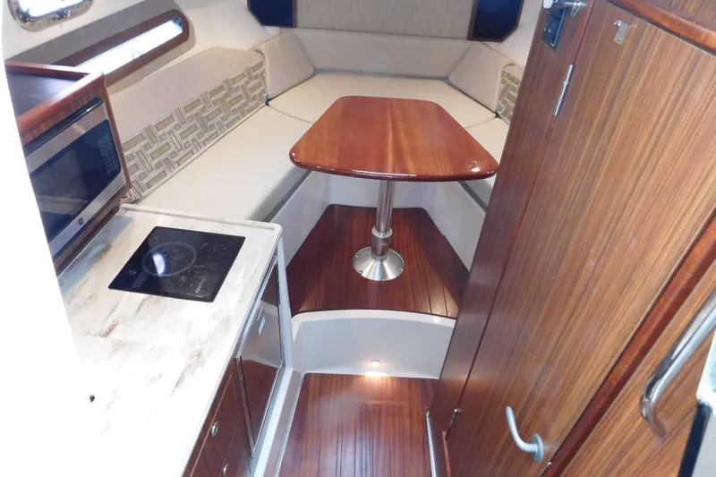 Slide: The Image of 2023 Pursuit OS 325 Offshore cabin interior with kitchenette and seating area. - 40