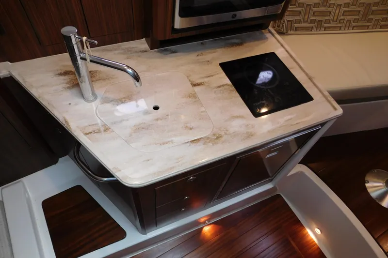 Slide: The Image of 2023 Pursuit OS 325 Offshore yacht kitchen with sink and induction cooktop. - 41