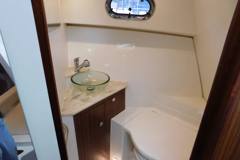 Slide: The Image of 2023 Pursuit OS 325 Offshore boat bathroom with glass sink and compact design. - 49