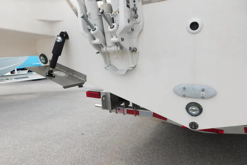 Slide: The Image of 2023 Pursuit OS 325 Offshore boat stern with trim tab and trailer detail. - 5