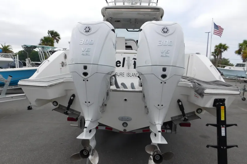 Slide: The Image of 2023 Pursuit OS 325 Offshore boat with dual Yamaha 300 V6 engines, docked outdoors. - 6