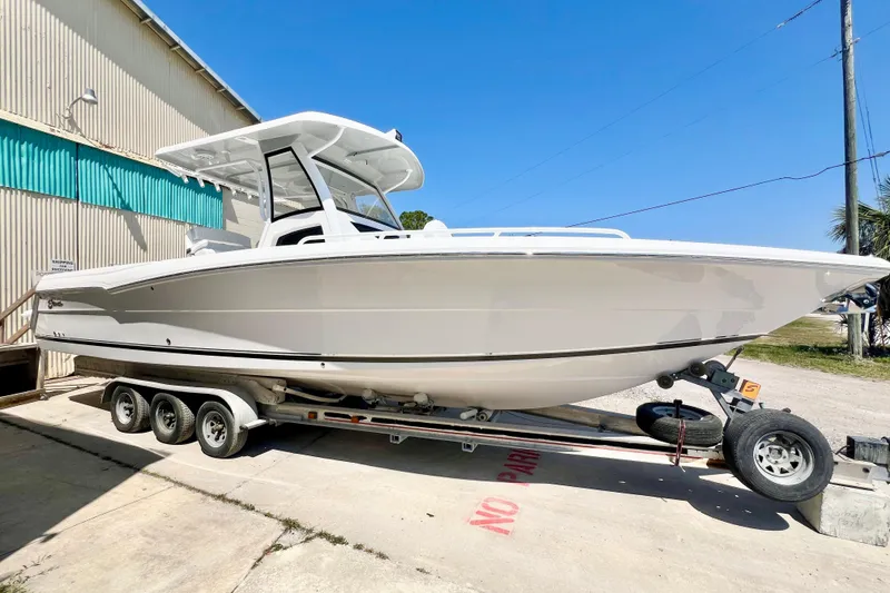 The Image of 2026 Stamas 33T Aventura boat on trailer, parked outdoors under clear blue sky. - 0