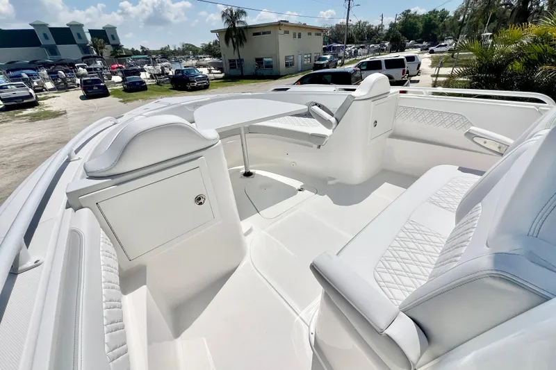 Slide: The Image of 2026 Stamas 33T Aventura boat interior with white seating and table, parked outdoors. - 21