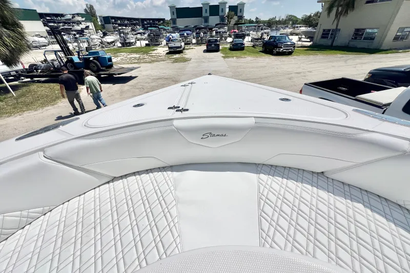 Slide: The Image of 2026 Stamas 33T Aventura boat interior with white quilted seating at a marina. - 23