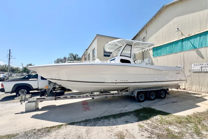 Slide: The Image of 2026 Stamas 33T Aventura boat on trailer, parked outside a warehouse. - 4