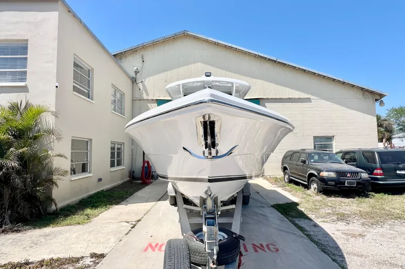 Slide: The Image of 2026 Stamas 33T Aventura boat on trailer, parked beside a building under clear blue sky. - 5