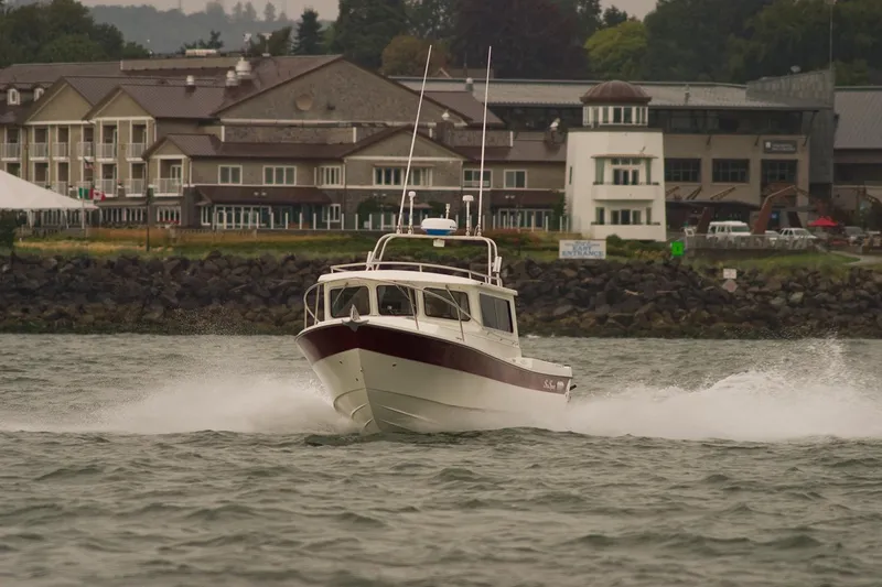 The Image of 2026 Sea Sport Sportsman 2200 boat cruising near waterfront buildings. - 0