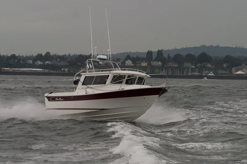 Slide: The Image of 2026 Sea Sport Sportsman 2200 navigating choppy waters near a coastal town. - 4