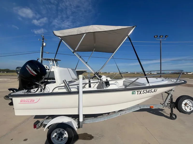 Slide: The Image of 2002 Boston Whaler 130 Sport boat with trailer and Bimini top. - 7