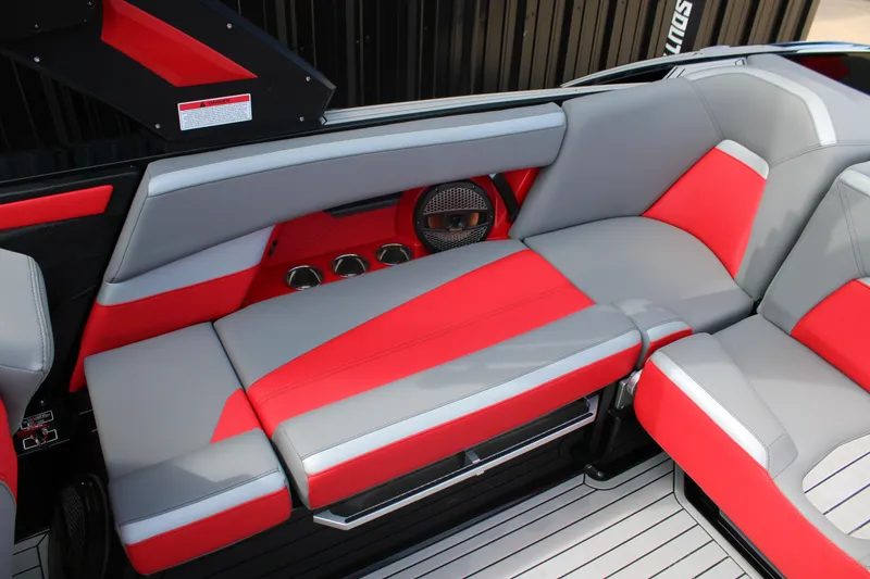 Slide: The Image of 2024 MasterCraft XStar S interior with red and gray seating, cup holders, and speaker. - 12