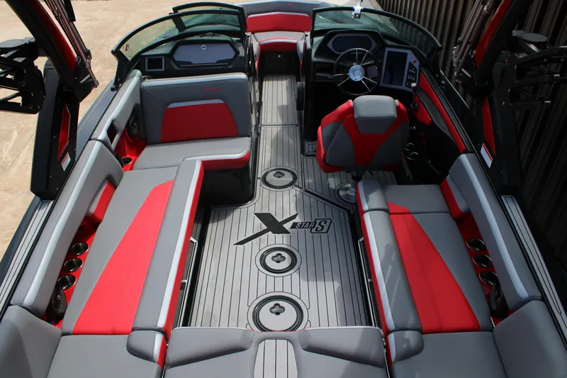 Slide: The Image of 2024 MasterCraft XStar S interior with red and gray seating, modern dashboard, and spacious layout. - 14
