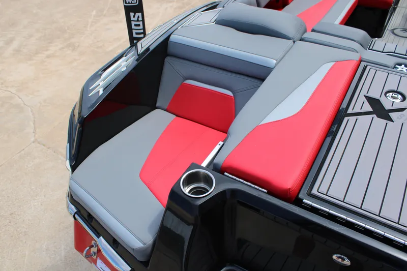 Slide: The Image of 2024 MasterCraft XStar S boat interior with red and gray seating and cup holder. - 15