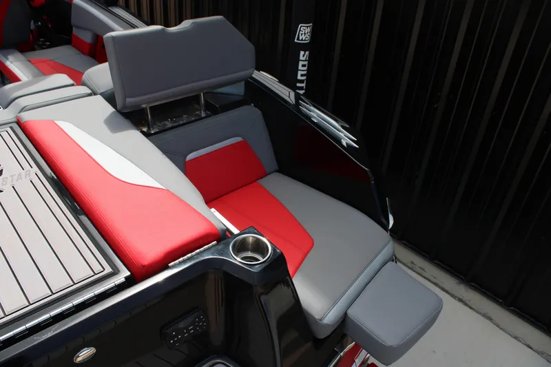 Slide: The Image of 2024 MasterCraft XStar S boat interior with red and gray seating, cup holder, and sleek design. - 16