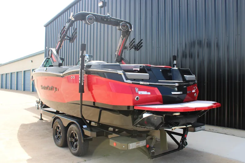 Slide: The Image of 2024 MasterCraft XStar S boat in vibrant red, parked near a storage facility. - 18