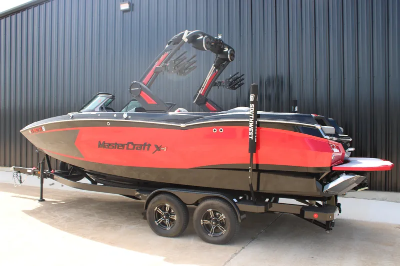 Slide: The Image of 2024 MasterCraft XStar S boat in red and black, parked on a trailer. - 3