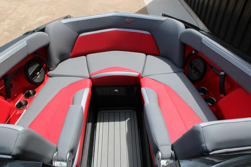 Slide: The Image of 2024 MasterCraft XStar S boat interior with red and gray seating, cup holders, and speakers. - 4