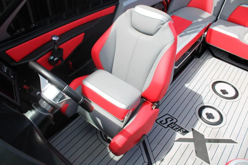 Slide: The Image of 2024 MasterCraft XStar S interior with red and gray seating, steering wheel, and deck design. - 6