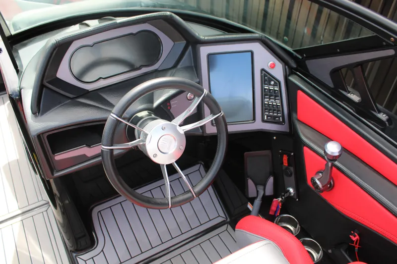 Slide: The Image of 2024 MasterCraft XStar S boat cockpit with steering wheel and digital controls. - 7