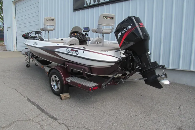 Slide: The Image of 2002 Triton Tr-176 SC boat with Mercury engine on trailer, parked outside a building. - 3