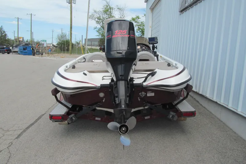 Slide: The Image of 2002 Triton Tr-176 SC boat with Mercury 125 engine, parked on pavement. - 4