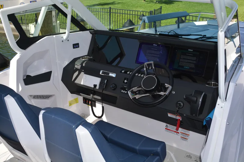 Slide: The Image of 2025 Axopar 29 Sun-Top boat cockpit with modern steering and dual displays. - 10