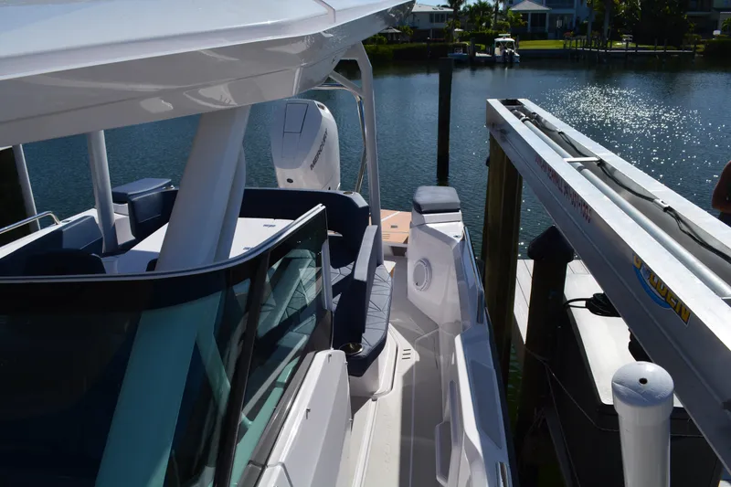 Slide: The Image of 2025 Axopar 29 Sun-Top boat docked by the water, showcasing sleek design and modern features. - 13
