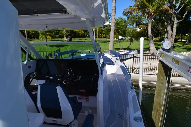 Slide: The Image of 2025 Axopar 29 Sun-Top boat docked, showcasing sleek design and modern cockpit. - 14