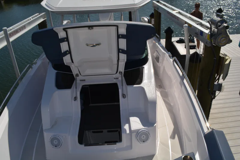 Slide: The Image of 2025 Axopar 29 Sun-Top boat interior with open storage compartment at dock. - 19