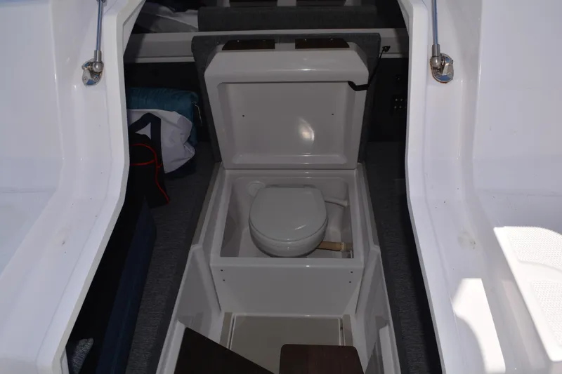 Slide: The Image of 2025 Axopar 29 Sun-Top boat interior with compact marine toilet. - 20