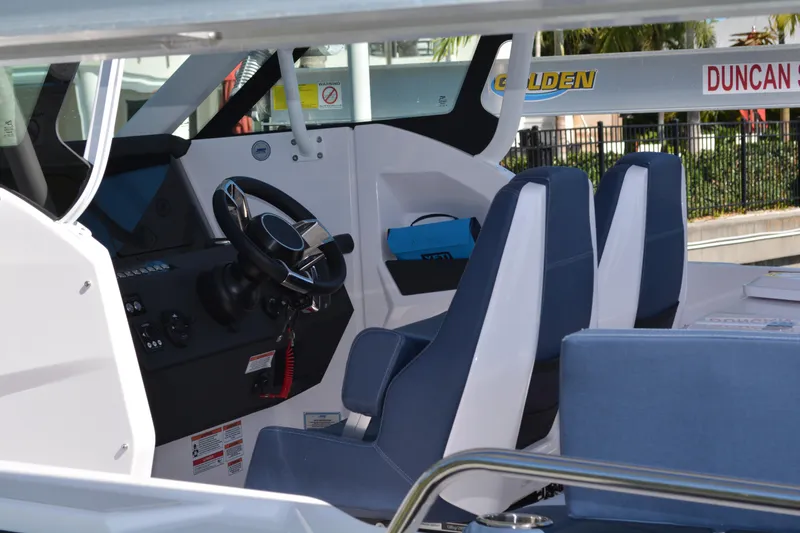 Slide: The Image of Interior view of 2025 Axopar 29 Sun-Top boat with modern steering and seating. - 22