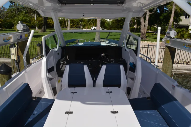 Slide: The Image of 2025 Axopar 29 Sun-Top boat interior with blue seating and modern dashboard. - 4