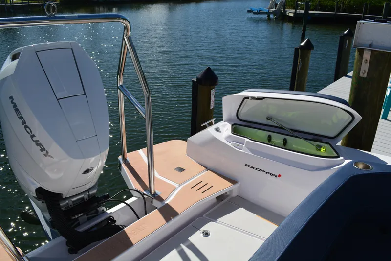 Slide: The Image of 2025 Axopar 29 Sun-Top boat with Mercury engine docked by the water. - 6